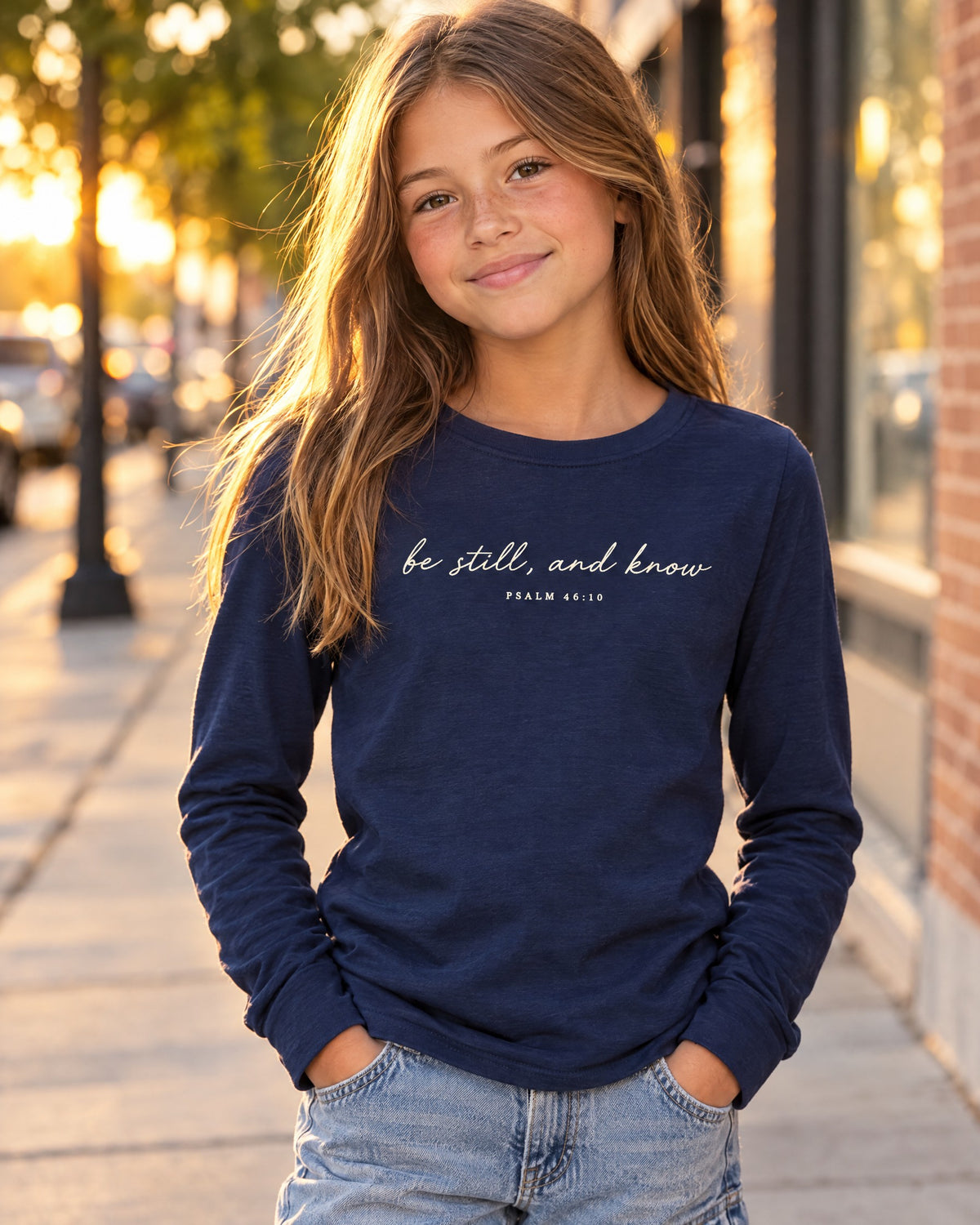 Kid wearing the Navy Be Still Kids Long Sleeve Tee – Minimal Psalm 46:10 Navy Christian Shirt - lifestyle photo, Cartsy