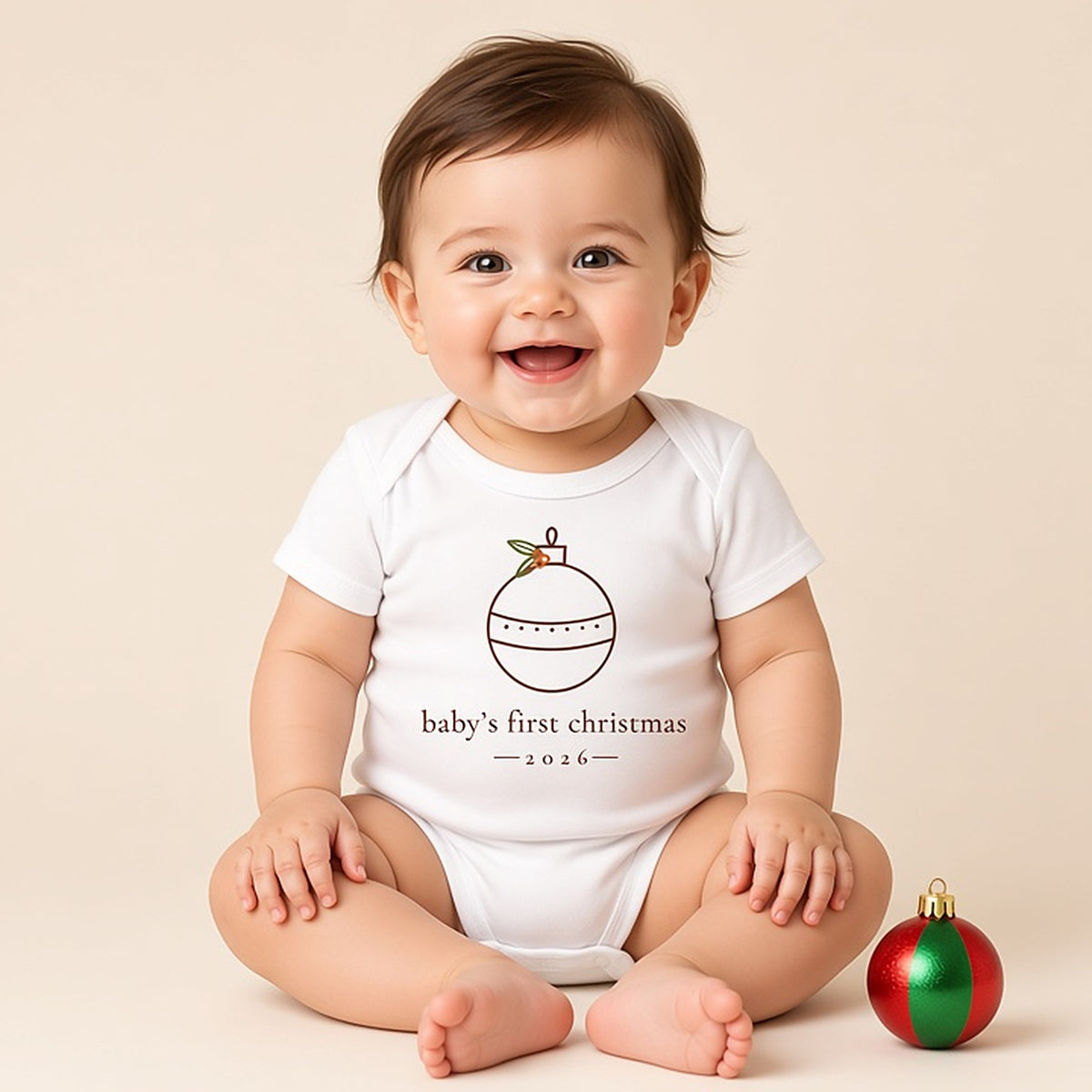 Baby in a white minimalist baby's first Christmas 2026 bodysuit with a fine-line ornament