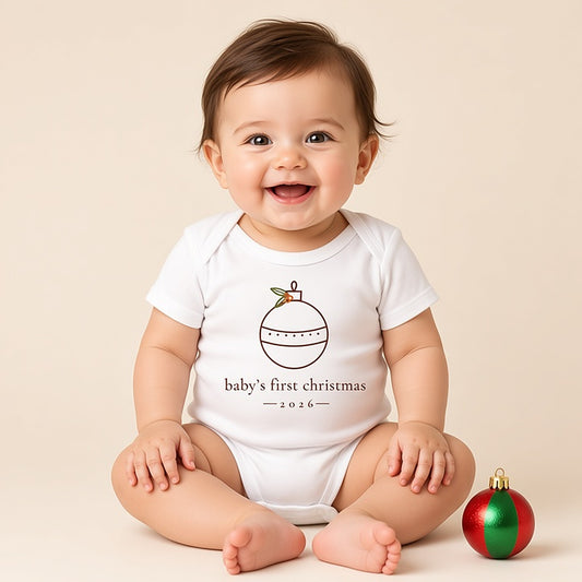 Baby in a white minimalist baby's first Christmas 2026 bodysuit with a fine-line ornament