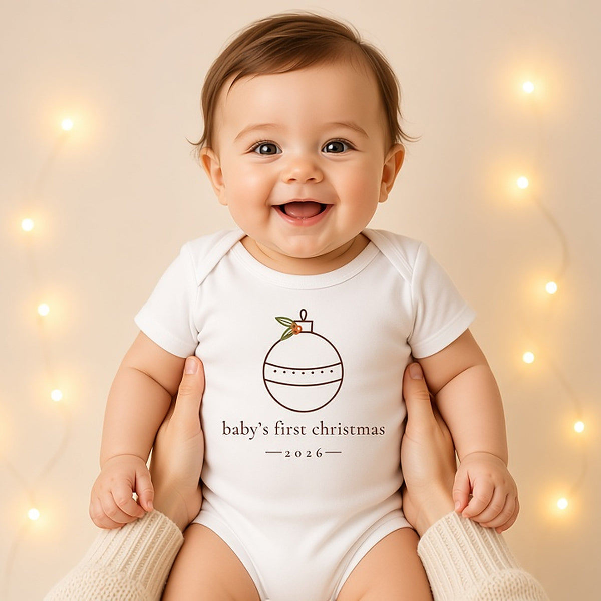 Baby in the minimalist baby's first Christmas 2026 bodysuit in a warm studio holiday portrait