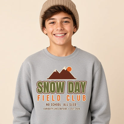 Boy in a beanie wearing the grey bold Snow Day Field Club kids winter sweatshirt