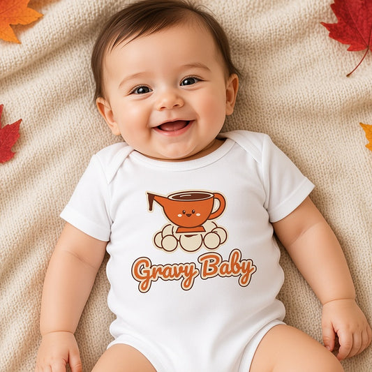Overhead view of a baby in the Gravy Baby bodysuit on a cream blanket with autumn leaves