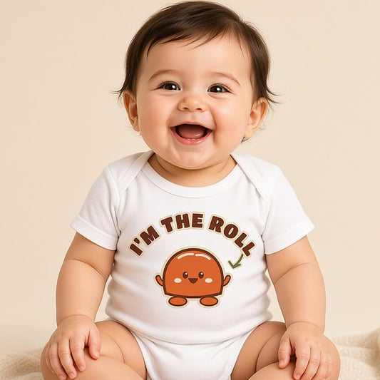 Giggling baby sitting in the white I'm the Roll funny Thanksgiving bodysuit