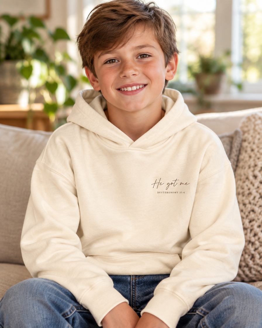 Kid wearing the Cartsy He Got Me Deuteronomy 31:6 Christian hoodie in ivory