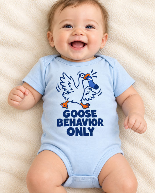 Giggling baby in the light blue Goose Behavior Only bodysuit on a cream blanket