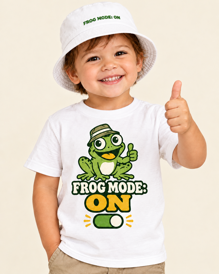 Toddler wearing the white Frog Mode ON bucket hat with the matching frog tee