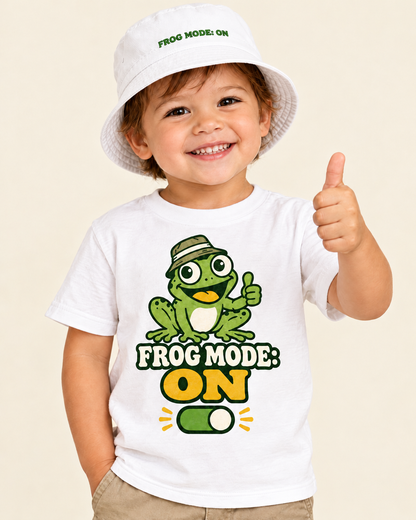 Toddler wearing the white Frog Mode ON bucket hat with the matching frog tee