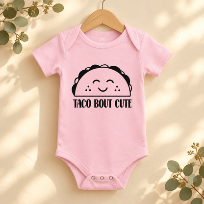 Taco 'Bout Cute Baby Bodysuit in Pink on a wooden hanger - Cartsy