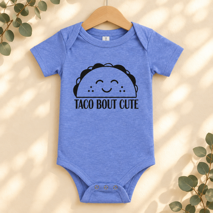Taco 'Bout Cute Baby Bodysuit in Heather Columbia Blue on a wooden hanger - Cartsy