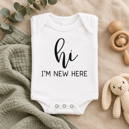 Hi I'm New Here Newborn Baby Bodysuit in White, folded flat lay - Cartsy
