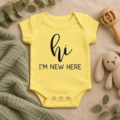 Hi I'm New Here Newborn Baby Bodysuit in Yellow, folded flat lay - Cartsy
