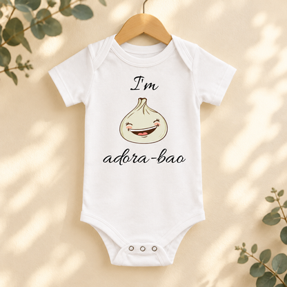 I'm Adora-Bao Dumpling Baby Bodysuit in White on a wooden hanger - Cartsy