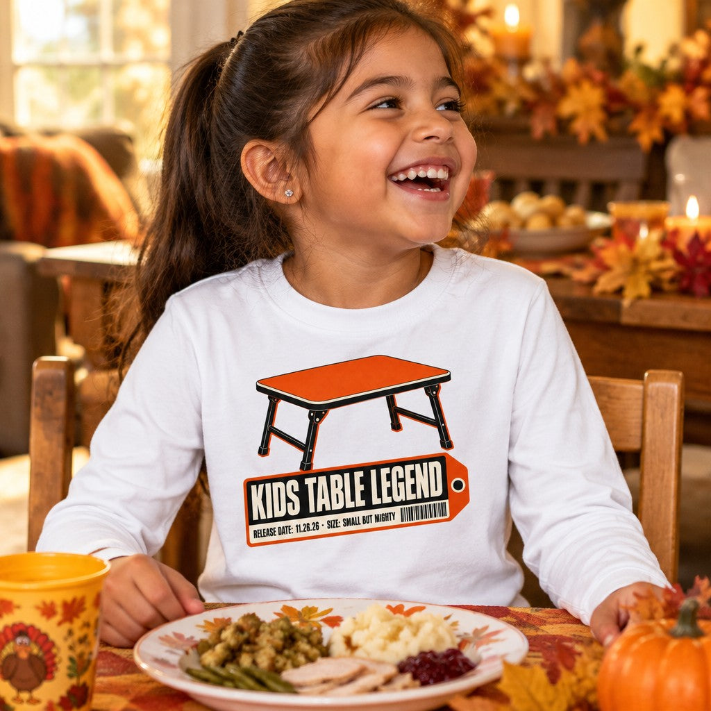 Kid wearing the Kids Table Legend Thanksgiving long sleeve tee with a retro folding table and Small but Mighty tag