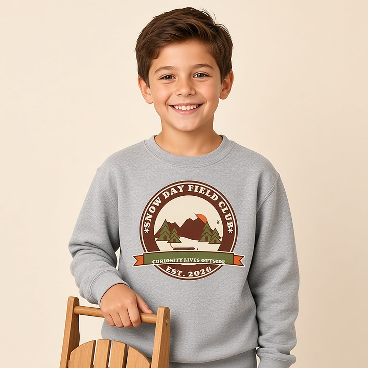 Boy in a grey Snow Day Field Club retro outdoor badge kids sweatshirt