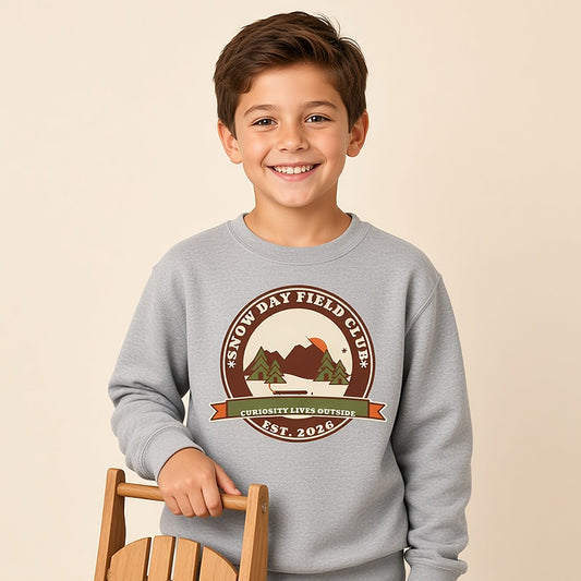 Boy in a grey Snow Day Field Club retro outdoor badge kids sweatshirt