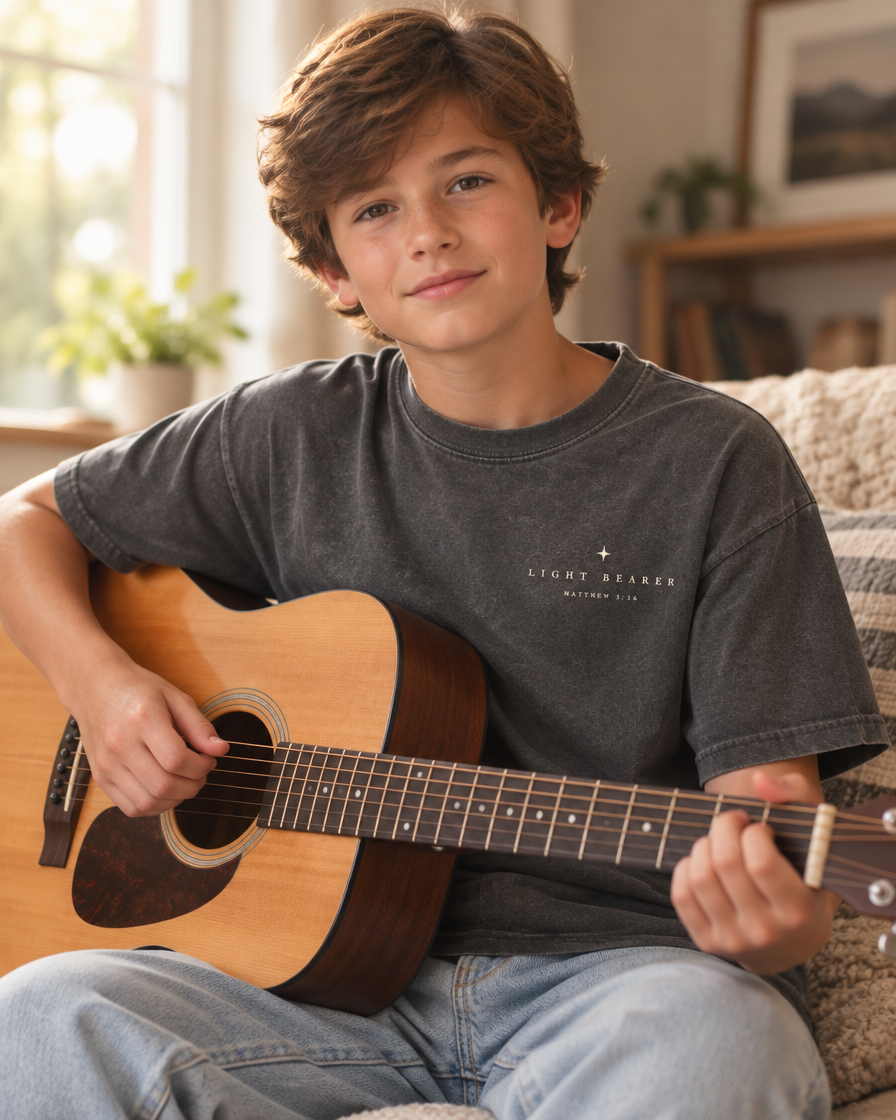 Kid wearing the Cartsy Light Bearer Matthew 5:16 washed black Christian tee