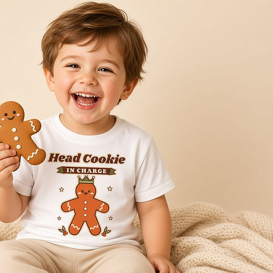 Toddler holding a gingerbread cookie in the white Head Cookie in Charge Christmas tee