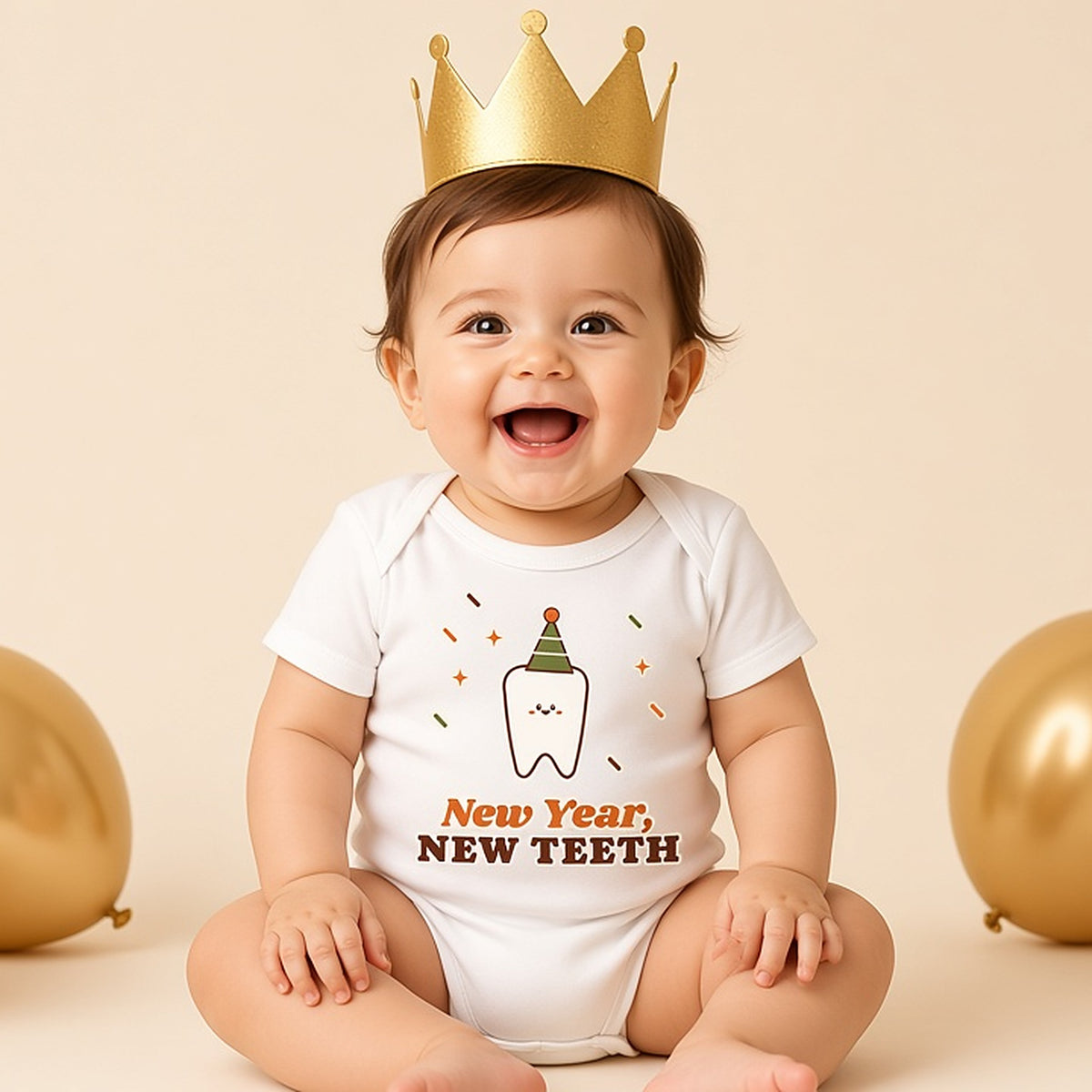 Baby in a gold paper crown and the New Year New Teeth bodysuit with balloons