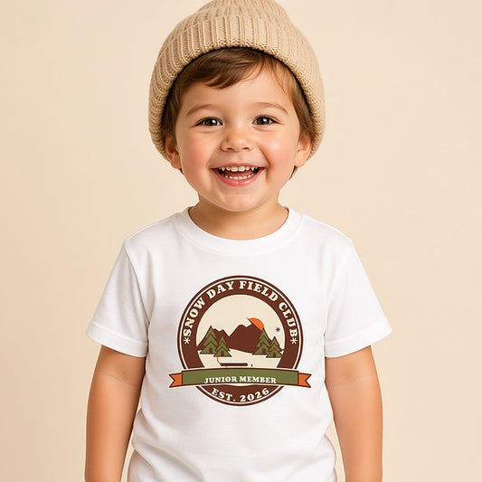 Toddler in a beanie wearing the white Snow Day Field Club Junior Member tee