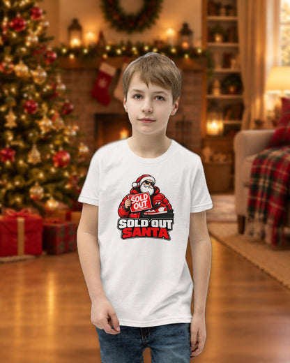Kid wearing the white Sold Out Santa tee in a cozy Christmas living room