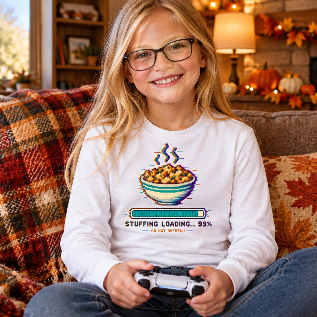 Kid wearing the Stuffing Loading 99% kids Thanksgiving long sleeve tee with a pixel-art stuffing loading bar