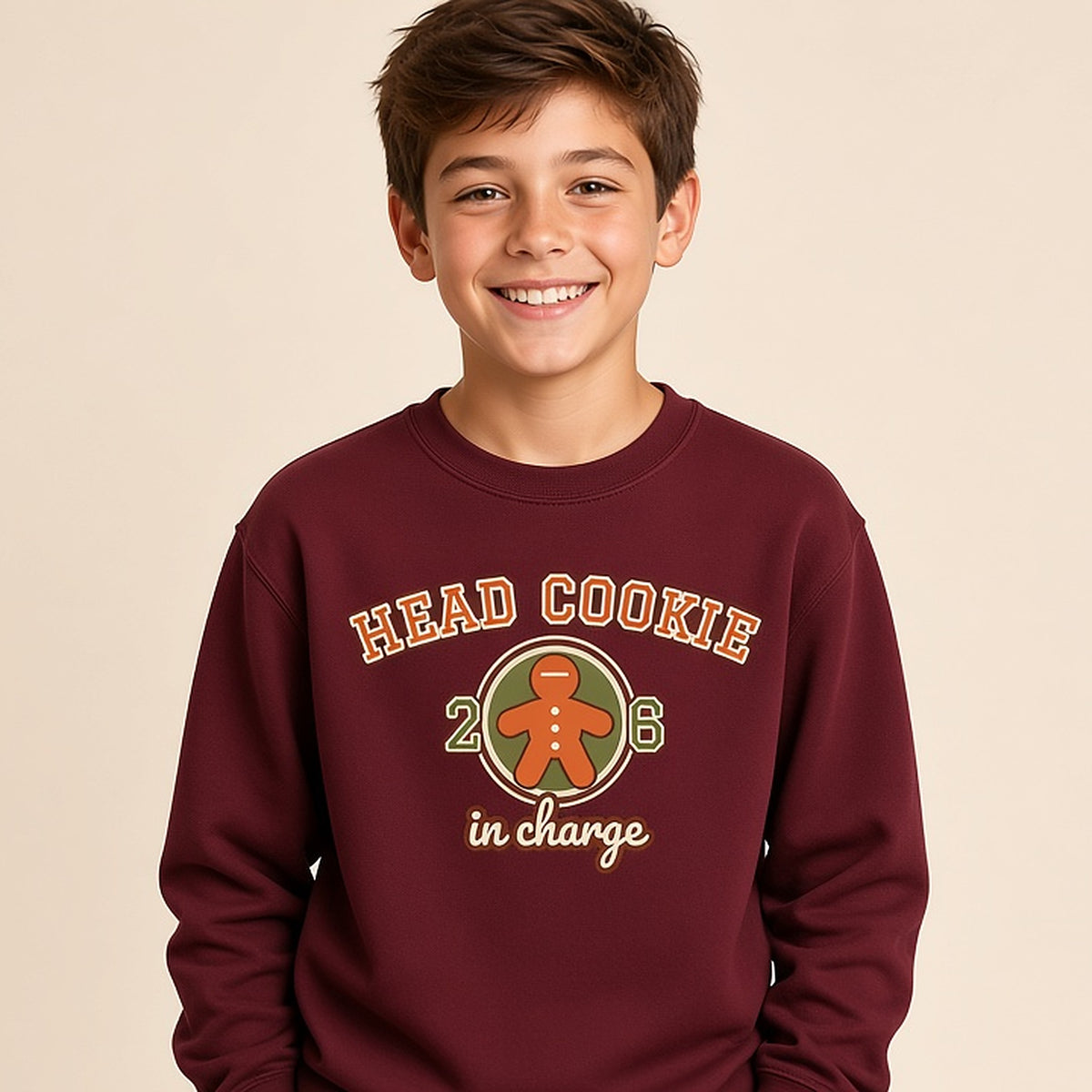 Boy in the maroon varsity Head Cookie in Charge kids Christmas sweatshirt with a gingerbread patch