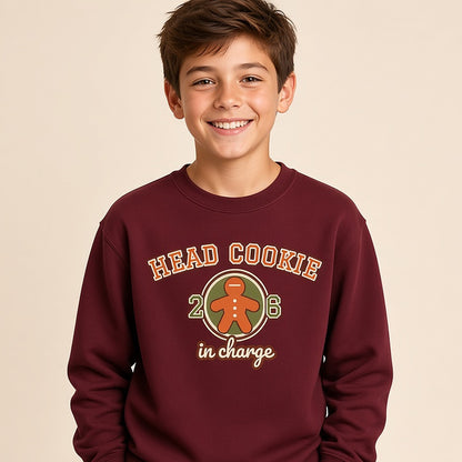 Boy in the maroon varsity Head Cookie in Charge kids Christmas sweatshirt with a gingerbread patch
