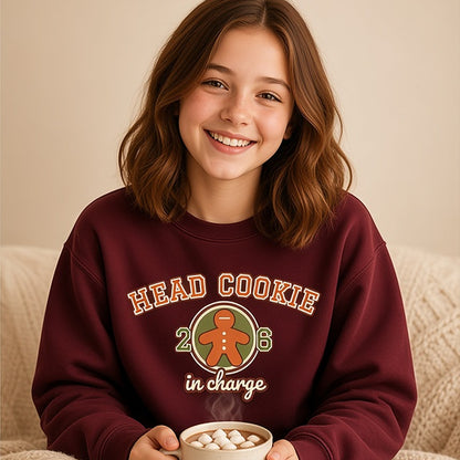 Girl holding hot cocoa in the maroon varsity Head Cookie in Charge kids sweatshirt