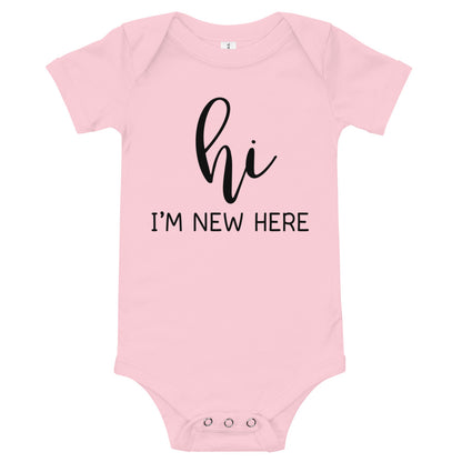 Pink baby bodysuit with 'hi' in script and 'I'M NEW HERE' in black capitals