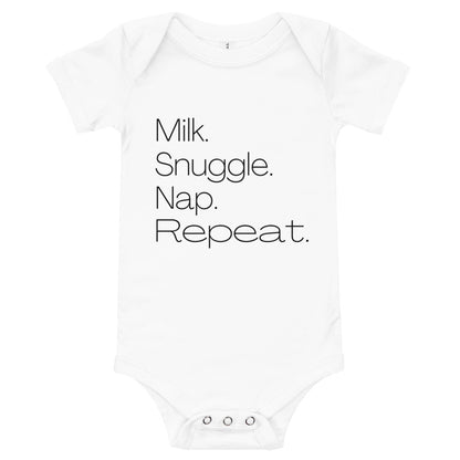 White baby bodysuit printed with 'Milk. Snuggle. Nap. Repeat.' in simple black type